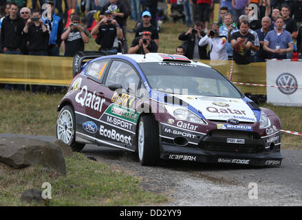 Baumholder, Germania. 24 Ago, 2013. Rally norvegese conducente Mads Ostberg e il suo co-driver Jonas Andersson guidare attraverso la blindatura sulla zona di addestramento militare durante la undicesima concorrenza dell' ADAC Rallye Deutschland vicino Baumholder, Germania, 24 agosto 2013. Foto: Thomas Frey/dpa/Alamy Live News Foto Stock