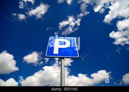 Parcheggio segno contro il cielo blu e nuvole bianche. Foto Stock
