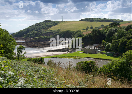 Polridmouth Beach, Cornwall, che è stato presentato in Daphne du Maurier romanzo Rebecca, con la giovane donna a piedi il percorso. Un REGNO UNITO Foto Stock