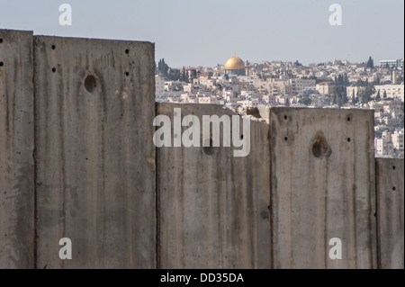 La Cupola della roccia è visibile sopra la separazione israeliano parete divisoria Territorio palestinese occupato nella città di Abu Dis. Foto Stock