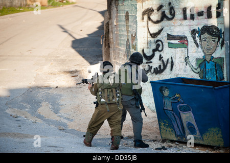 Soldati israeliani occupano le strade principali della Cisgiordania villaggio di bulino. Foto Stock