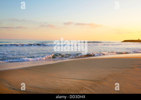 Tramonto sulla spiaggia con piccole onde ( Sitges, Barcelona, Spagna) Foto Stock