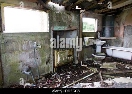 Una vecchia stufa e stanza da bagno di suite in un negligente croft casa isola di Lewis UK. Foto Stock