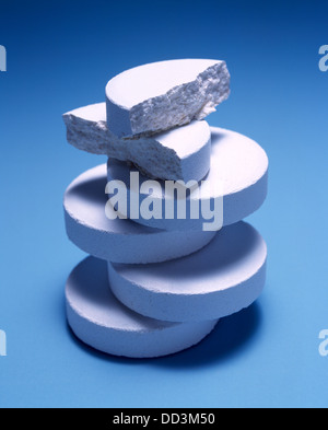 Una grande pila di medicina bianco compresse su uno sfondo blu. Foto Stock