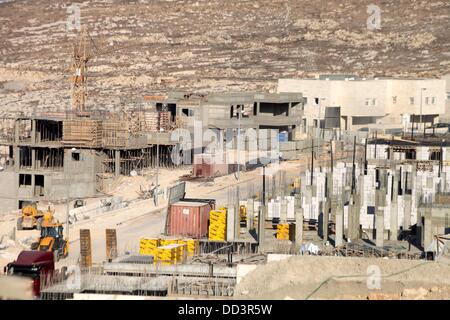 Gerusalemme, Gerusalemme, Territorio palestinese. 25 Ago, 2013. Gli operai lavorano presso il cantiere di Pisgat Zeev, un insediamento urbano in una zona annessa Israele a Gerusalemme dopo la sua cattura nel 1967 il Medio Oriente guerra, vicino al villaggio arabo di Beit Hanina, Agosto 25, 2013. Il presidente palestinese Mahmoud Abbas la scorsa settimana ha ribadito il suo impegno a favore di una soluzione a due stati che dovrebbe vedere la creazione di uno Stato palestinese indipendente sul pre 1967 linee con Gerusalemme come capitale, accusando Israele di immissione "ostacoli" sulla strada per il proseguimento dei negoziati di pace perseguendo co Foto Stock