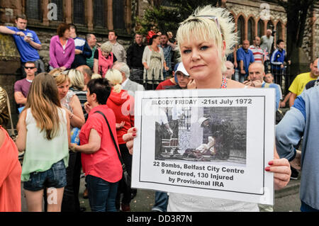 Belfast, Irlanda del Nord. 25 Ago, 2013. Liz Bingham, figlia di assassinati UVF chief John Bingham, protesta contro una parata repubblicana che tiene un banner con una fotografia da "Bloody Venerdi', 21 luglio 1972, quando l'ira esplose 22 bombe a Belfast City Centre, uccidendo 9 persone e il ferimento di altre 130 Credito: Stephen Barnes/Alamy Live News Foto Stock