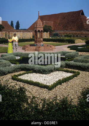 Una coppia di mezza età dalla fonte e Star Pool, Cressing Temple Barn Tudor walled gardens, Essex Foto Stock