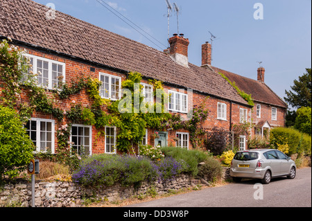 Una fila di terrazze coltivate a mattoni rossi cottages in Steeple Langford , Wiltshire , Inghilterra , Inghilterra , Regno Unito Foto Stock
