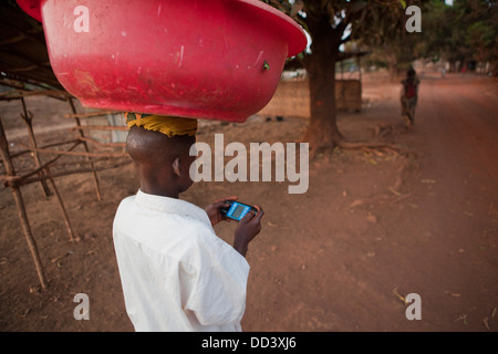 Ragazzo multi-tasking in Port Loko, Sierra Leone. Foto Stock