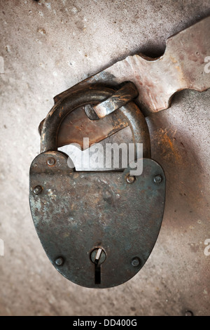 Vecchia serratura arrugginita appeso sulla porta di metallo. Close-up foto Foto Stock