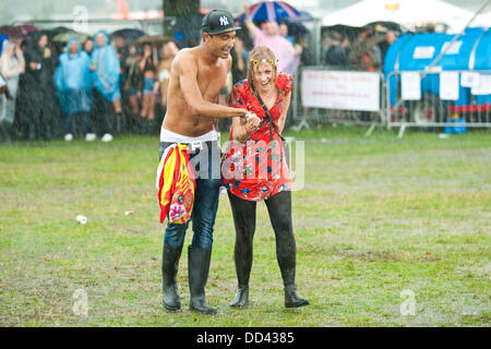 Londra, Regno Unito. 24 Ago, 2013. I frequentatori del festival brave la pioggia durante il giorno uno del sud ovest quattro music festival a Clapham Common, Londra. Credito: Robert Fisher/Alamy Live News Foto Stock