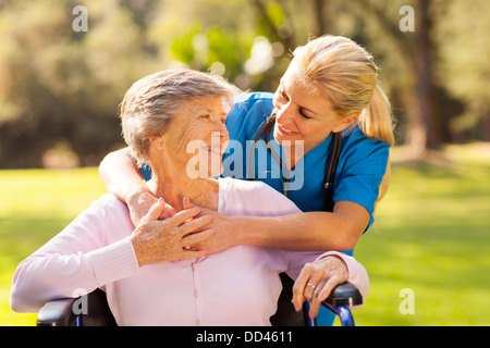 Caring infermiera con paziente senior all'aperto Foto Stock