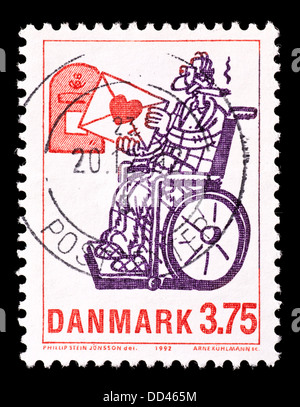 Francobollo dalla Danimarca raffigurante un uomo in sedia a rotelle. Foto Stock