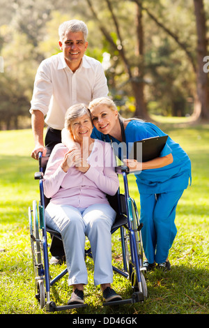 Cura l'infermiera abbracciando senior all'esterno del paziente Foto Stock