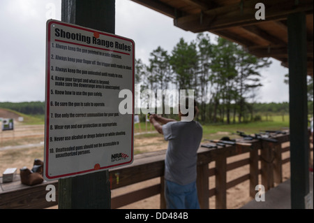 Senior uomo sparare la sua pistola al poligono di tiro in Ocala, Foresta Nazionale USA con la gamma delle regole postato il colore del primo piano Foto Stock