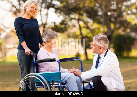 Medico di sesso maschile di parlare con handicap donna senior presso la casa di riposo Foto Stock