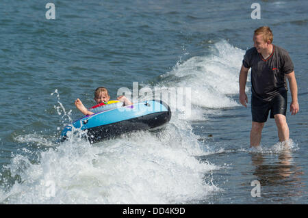 Aberystwyth, UK. 26 Ago, 2013. Un padre e figlia giocando in mare e godersi il caldo clima soleggiato su agosto lunedì festivo a Aberystwyth, sulla West Wales coast. Credito: keith morris/Alamy Live News Foto Stock