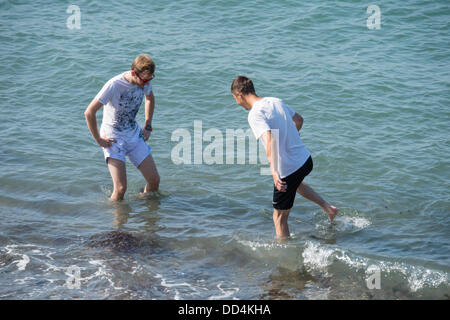 Aberystwyth, UK. 26 Ago, 2013. Due giovani uomini paddling in mare e godersi il caldo clima soleggiato su agosto lunedì festivo a Aberystwyth, sulla West Wales coast. Credito: keith morris/Alamy Live News Foto Stock