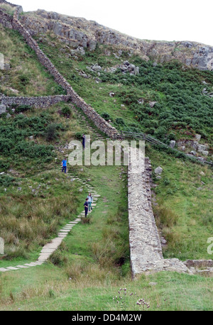 I visitatori a piedi lungo la sezione del Muro di Adriano nei pressi di Hexham, Northumberland, Inghilterra Foto Stock