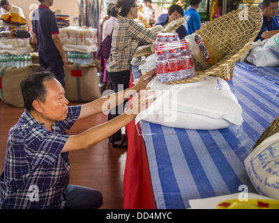 Bangkok, Tailandia. 26 Ago, 2013. Un uomo che prega sul riso egli sta donando al Poh Teck Tung Foundation per fame Ghost mese in Bangkok. Poh Teck Tung opera negli ospedali e nelle scuole e fornisce assistenza ai poveri in Thailandia. Il settimo mese lunare (Agosto - Settembre 2013) è quando la comunità cinese crede che hell's gate viene aperto per consentire spiriti di muoversi liberamente nel mondo umano per un mese. Molte case e templi terrà cerimonie di preghiera per tutto il mese-lungo la Fame Festival fantasma (Phor Thor) per placare gli spiriti. Foto Stock