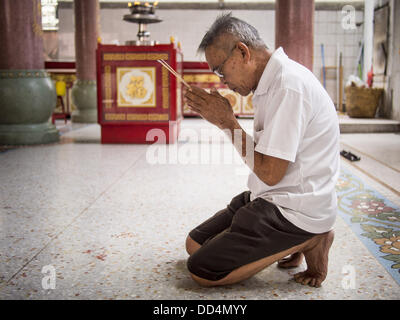 Bangkok, Tailandia. 26 Ago, 2013. Un uomo che prega al Poh Teck Tung Foundation durante la fame Ghost mese in Bangkok. Poh Teck Tung opera negli ospedali e nelle scuole e fornisce assistenza ai poveri in Thailandia. Il settimo mese lunare (Agosto - Settembre 2013) è quando la comunità cinese crede che hell's gate viene aperto per consentire spiriti di muoversi liberamente nel mondo umano per un mese. Molte case e templi terrà cerimonie di preghiera per tutto il mese-lungo la Fame Festival fantasma (Phor Thor) per placare gli spiriti. Foto Stock