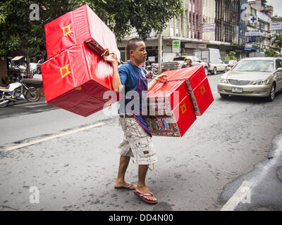 Bangkok, Tailandia. 26 Ago, 2013. Un uomo porta bare per essere bruciato in Hungry Ghost rituali mese attraverso le strade di Bangkok. Il settimo mese lunare (Agosto - Settembre 2013) è quando la comunità cinese crede che hell's gate viene aperto per consentire spiriti di muoversi liberamente nel mondo umano per un mese. Molte case e templi terrà cerimonie di preghiera per tutto il mese-lungo la Fame Festival fantasma (Phor Thor) per placare gli spiriti. Foto Stock