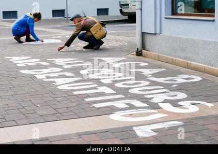 Scrivere gli attivisti anti razzista di slogan per protestare sulla strada contro l'Anti Romany marzo dell ala destra estremisti in Ceske Budejovice, Repubblica Ceca il 24 agosto 2013. L'ala destra gli estremisti hanno marciato su questo percorso in Budejovice. (CTK foto/David Veis) Foto Stock