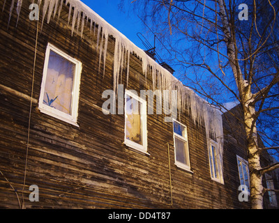 Ghiaccioli sul tetto di una casa in legno Foto Stock