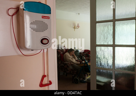 Una vecchia signora dorme nella sua warden bungalow assistita con un operaio chiamata sistema di allarme e di tirare la cordicella per qualsiasi emergenza. Foto Stock