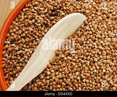 Semole e semolini di grano saraceno in una ciotola su una tavola di legno Foto Stock