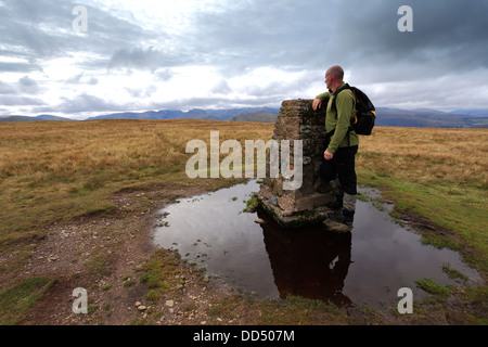 Walker, l'ordinanza sondaggio punto Trig al vertice della collina Loadpot cadde, Parco Nazionale del Distretto dei Laghi, Cumbria County, Inghilterra Foto Stock