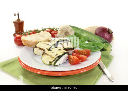 Zucchine ripiene rotoli e i pomodori su una piastra bianca Foto Stock