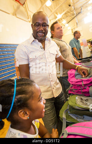 Darius Rucker di Hootie e Blowfish distribuire zaini per bambini durante il Hootie Homegrown Roundup il 24 agosto 2013 a Charleston, Carolina del Sud. Il Roundup distribuisce forniture scolastiche, dentale e gli esami oculistici e parrucchieri per studenti svantaggiati nella contea di Charleston. Foto Stock