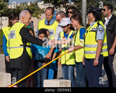 Gerusalemme, Israele. Il 27 agosto, 2013. Studente road safety controlla salutare il Presidente Shimon Peres per il suo arrivo al 'Pace Scuola Elementare', chiamato dopo ex PM Rabin, per prendere parte all'apertura del nuovo anno scolastico. Gerusalemme, Israele. 27-Agosto-2013. Il Presidente Shimon Peres e sindaco di Barkat Nir aprire l anno scolastico presso la "Pace Scuola Elementare' denominata dopo ex PM Rabin. Credito: Nir Alon/Alamy Live News Foto Stock