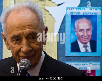 Gerusalemme, Israele. Il 27 agosto, 2013. Il Presidente dello Stato di Israele, Shimon Peres, saluta prime livellatrici sul loro primo giorno di scuola presso la "Pace Scuola Elementare'. Un ritratto di Peres si blocca sulla classe bulletin board dietro di lui. Gerusalemme, Israele. 27-Agosto-2013. Il Presidente Shimon Peres e sindaco di Barkat Nir aprire l anno scolastico presso la "Pace Scuola Elementare' denominata dopo ex PM Rabin. Credito: Nir Alon/Alamy Live News Foto Stock