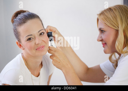 Medico ORL esaminando l'orecchio dal paziente di sesso femminile Foto Stock