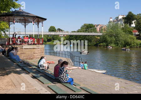 Una giornata di sole in Chester sulle rive del fiume Dee incoraggia le persone a sedersi per un po' di tempo a guardare le barche che vanno da. Foto Stock