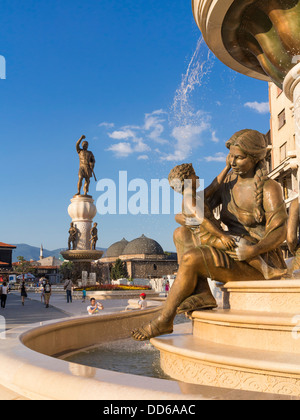 Le Madri della Macedonia Fontana, Skopje, Macedonia nella ribellione piazza con il nuovo monumento del guerriero dietro Foto Stock