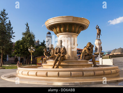 Skopje, Macedonia - Le madri di Macedonia Fontana statue, nella ribellione piazza con il monumento del guerriero dietro Foto Stock
