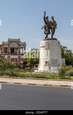 Dakar, Senegal. Place du Tirailleur con statua a Demba e Dupont, eroi della guerra mondiale I. Dakar stazione ferroviaria in background. Foto Stock