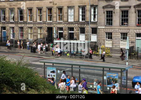 Persone in attesa alle fermate degli autobus al centro di Edimburgo in Scozia Foto Stock