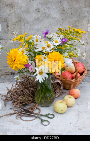 Bouquet di fiori gialli e chamomiles e mele ancora vita Foto Stock