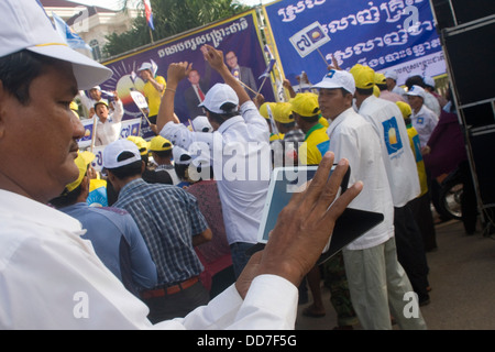 Un uomo è utilizzando un computer tablet durante una campagna elettorale rally per opporsi CNRP guidato da Sam Rainsy in Kampong Cham, Cambogia Foto Stock