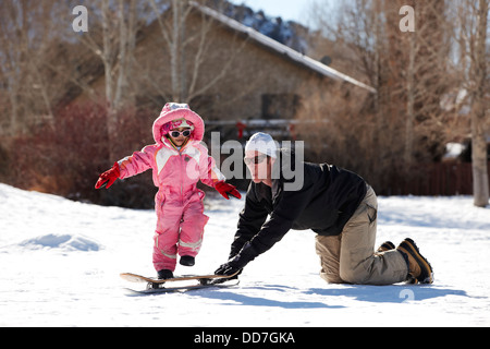 Padre e figlia a giocare nella neve Foto Stock