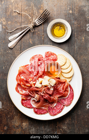 Piatto di un assortimento di snack prosciutto, salame, formaggio e miele Foto Stock