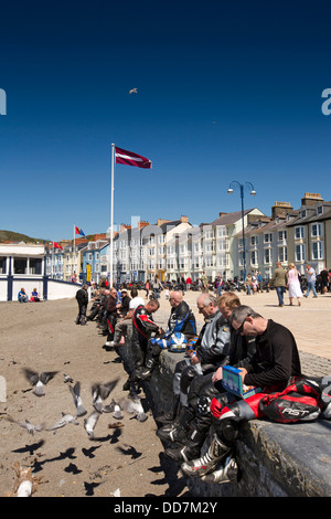 Regno Unito, Galles Ceredigion, Aberystwyth, visitatori motociclista seduto sul lungomare Foto Stock