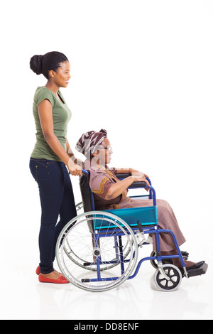 Bella giovane donna africana spingendo la nonna sulla sedia a rotelle isolato su bianco Foto Stock