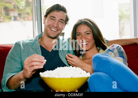 Paio mangiare popcorn sul divano Foto Stock