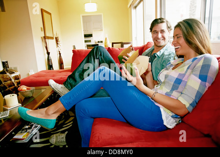 Paio mangiare prendere il cibo sul divano Foto Stock