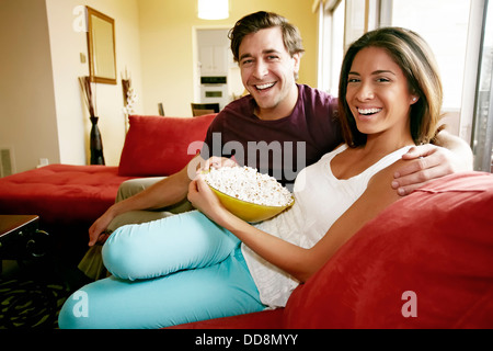 Paio mangiare popcorn sul divano Foto Stock